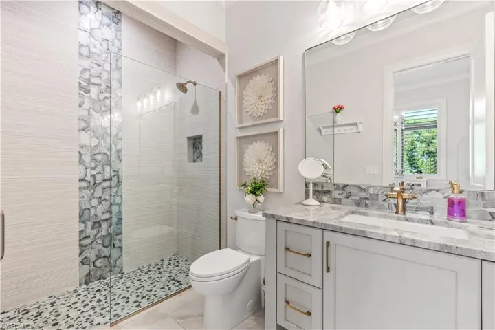 Bathroom with vanity, an enclosed shower, and toilet