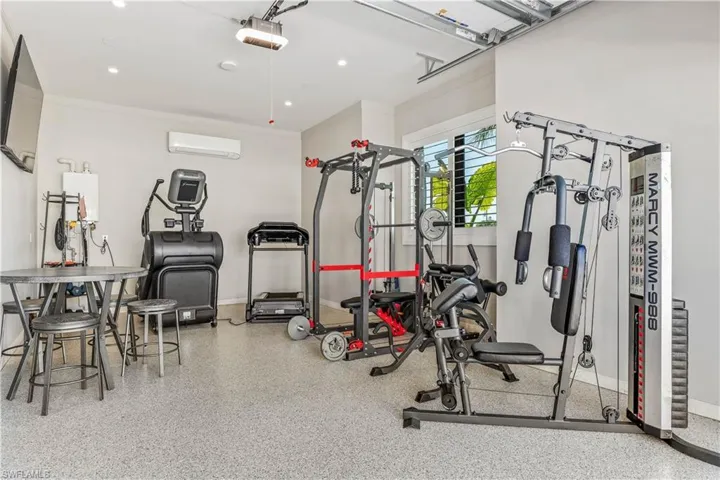 Exercise room with an AC wall unit and crown molding