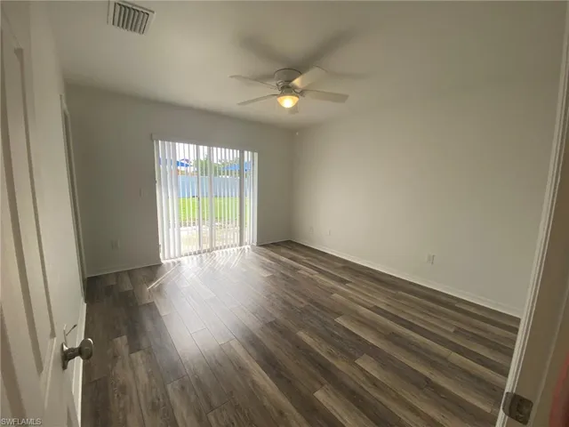 Master bedroom with ceiling fan and sliding glass door to back yard.