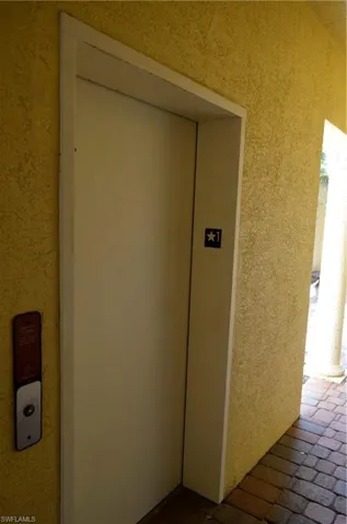 Doorway to property featuring elevator and stucco siding