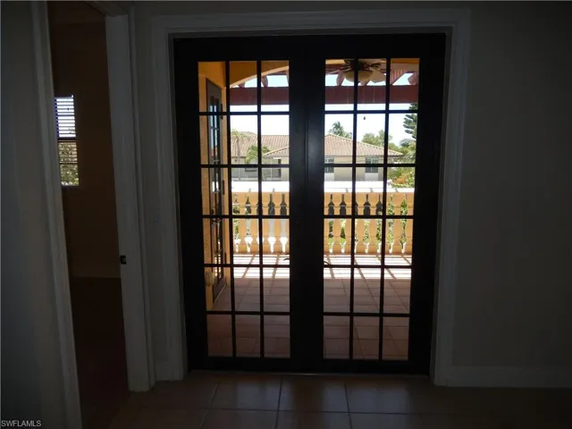 Doorway with tile patterned floors and baseboards