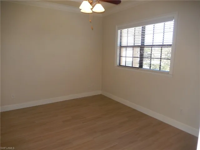 Spare room featuring crown molding, light wood finished floors, and ceiling fan