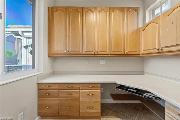 Unfurnished office with tile patterned floors and baseboards