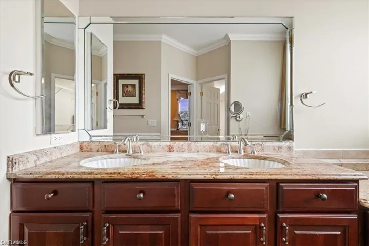 Full bathroom featuring double vanity and ornamental molding