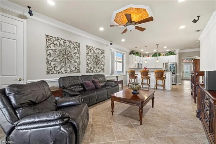 Living area featuring ceiling fan, crown molding, and recessed lighting