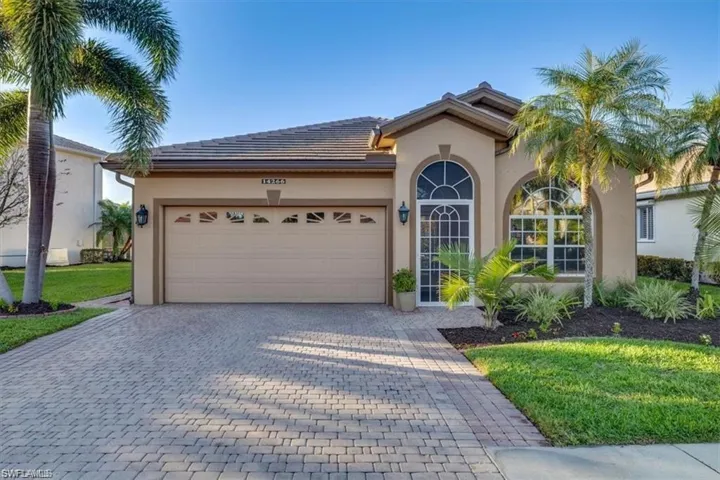 View of front facade with decorative driveway, a garage, stucco siding, and a front lawn