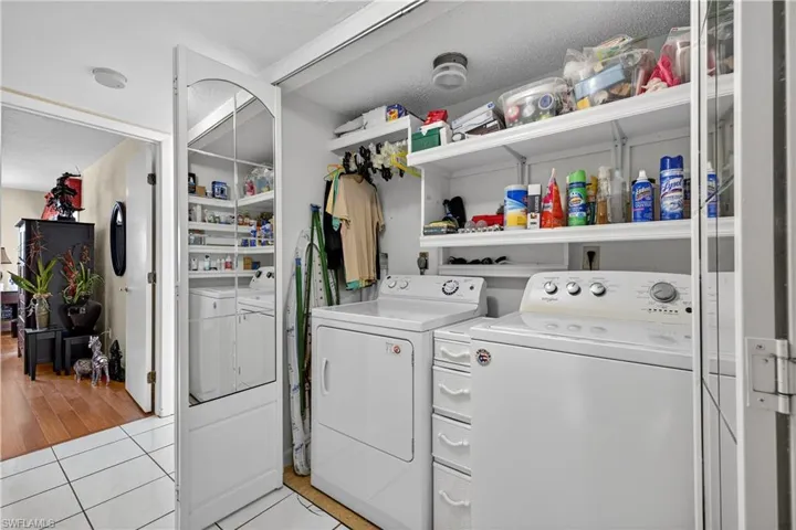 Laundry room with washer and dryer and light tile patterned floors