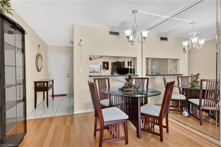 Dining space with light wood-type flooring and a chandelier