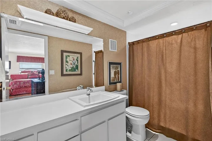 Full bath with vanity, a shower with shower curtain, ensuite bathroom, and crown molding