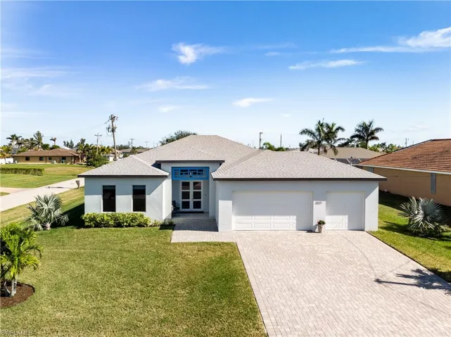 View of front of house with a garage and a front lawn