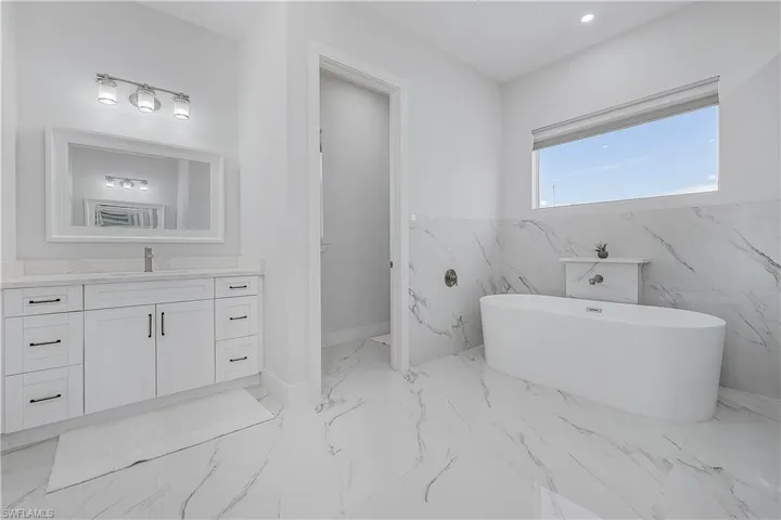 Bathroom featuring vanity, toilet closet, and a bathtub