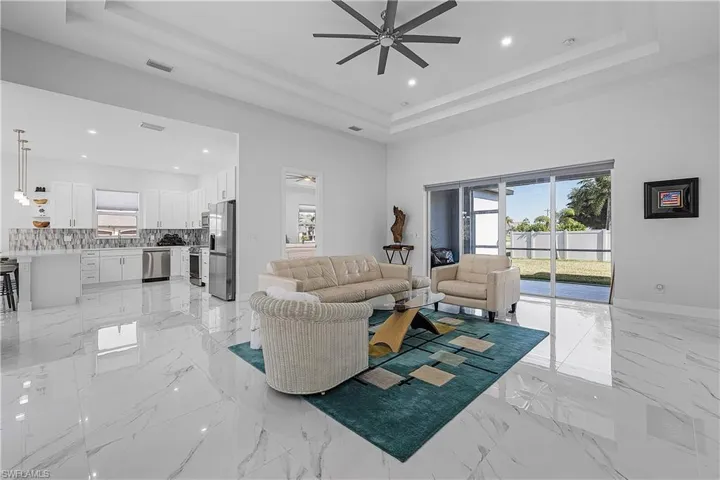 Living room with a tray ceiling and ceiling fan