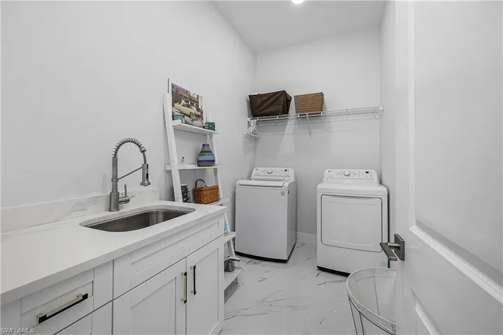 Laundry room with sink, cabinets, and washer and dryer