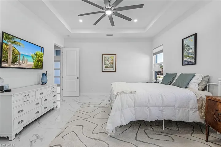 Bedroom featuring a raised ceiling and ceiling fan