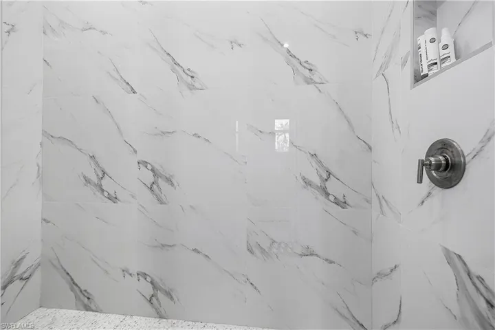 Primary bathroom featuring tiled shower