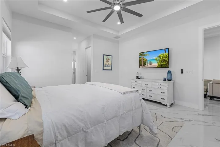 Bedroom featuring a raised ceiling and ceiling fan