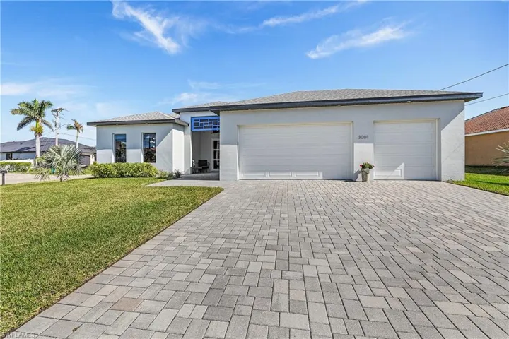 View of front of house with a garage and a front lawn