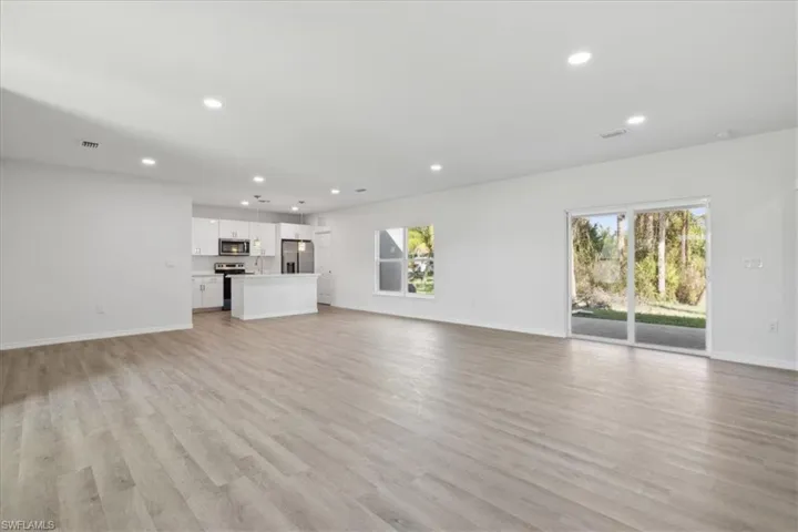 Unfurnished living room featuring plenty of natural light and light wood-type flooring