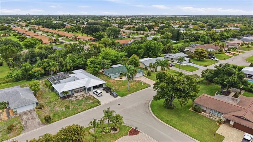 Aerial perspective of a residential neighborhood with a variety of single-story homes featuring mature trees and lush landscaping