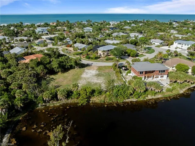 Expansive lot featuring a cleared building envelope, mature tropical landscaping, and a waterfront boundary