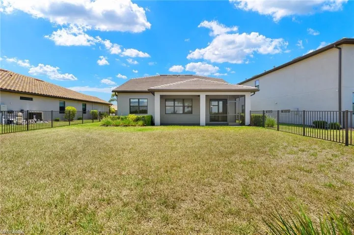 Rear view of property featuring a sunroom and a lawn
