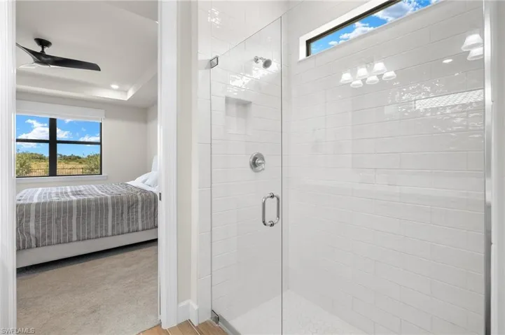 Bathroom with walk in shower, hardwood / wood-style flooring, and ceiling fan