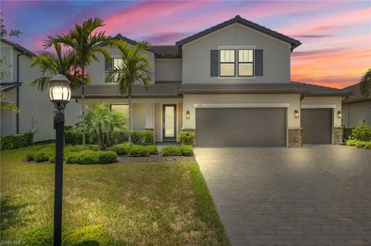 View of front of property featuring a garage and a lawn