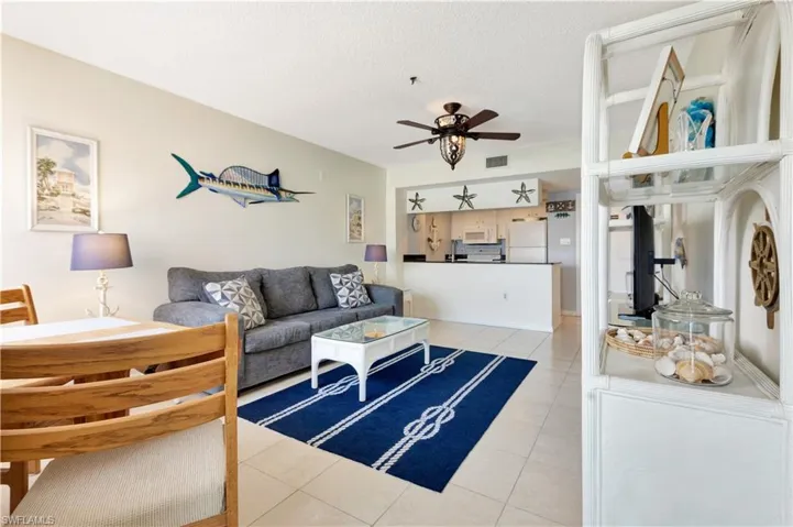 Living area featuring light tile patterned floors, a ceiling fan, and a textured ceiling