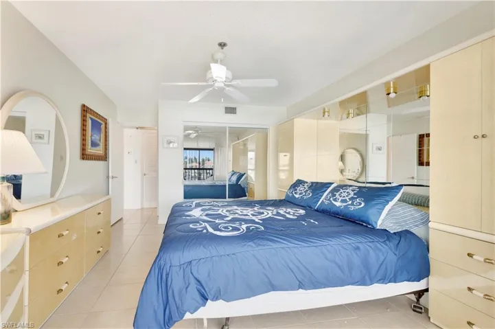 Bedroom featuring light tile patterned floors, a ceiling fan, and a closet