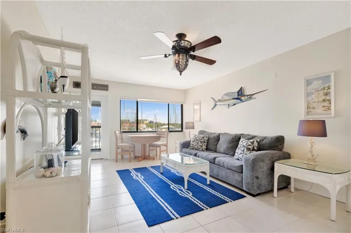 Living area featuring a ceiling fan, a textured ceiling, and light tile patterned floors