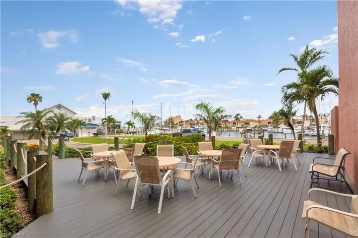 Wooden terrace featuring outdoor dining area and a water view