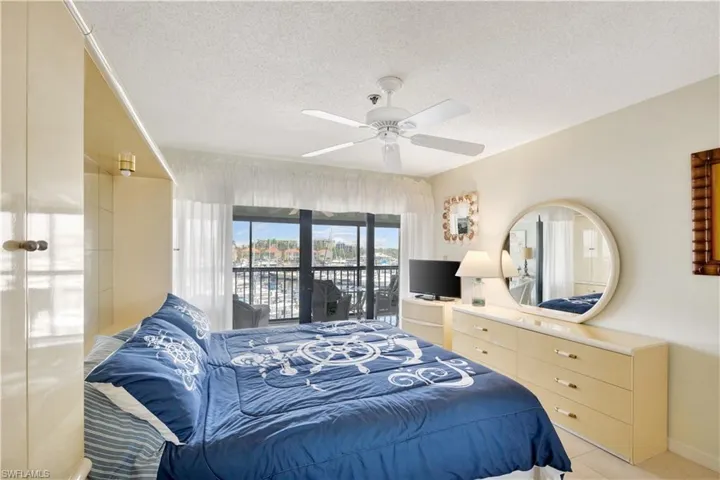 Bedroom featuring access to outside, a textured ceiling, ceiling fan, and light tile patterned floors