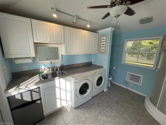 Laundry room with washing machine and dryer, a ceiling fan, and track lighting
