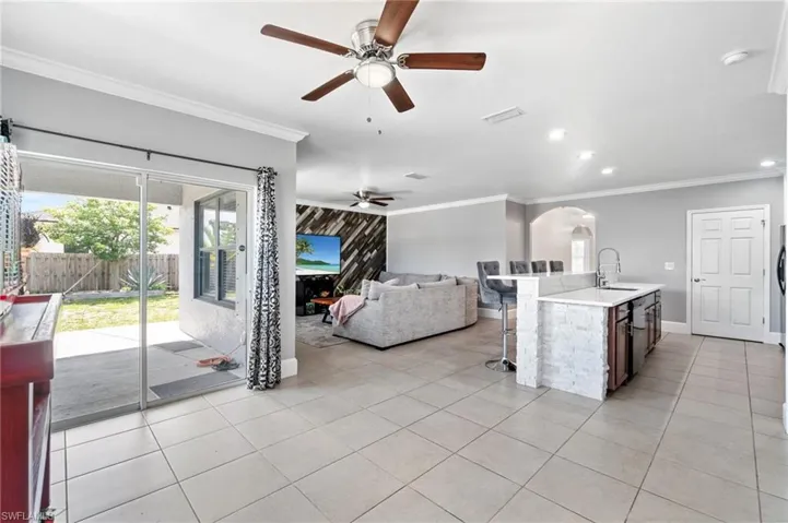Kitchen with light tile floors, eating area, extended kitchen island with sink