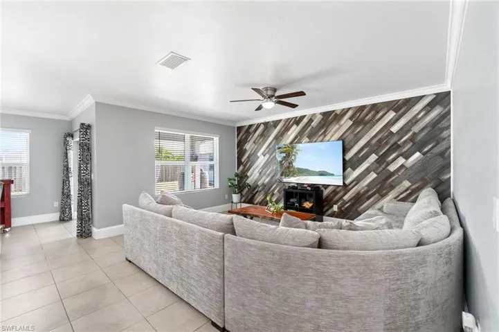 Living room with tile flooring, custom crown molding and decorative wood wall