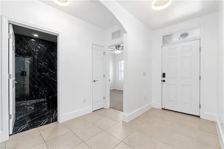 Tiled entryway featuring custom lighting.