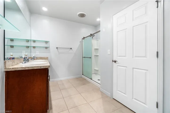 Primary bathroom featuring large shower, tile floor, and oversized vanity