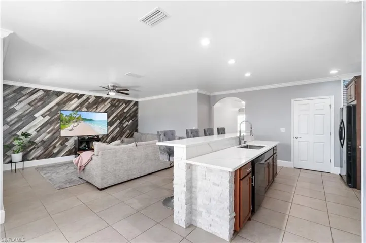 Kitchen with extended island sink, light tile flooring
