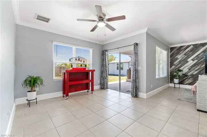 Dining area featuring a ton of sunlight, ceiling fan, light tile floors, and custom crown molding