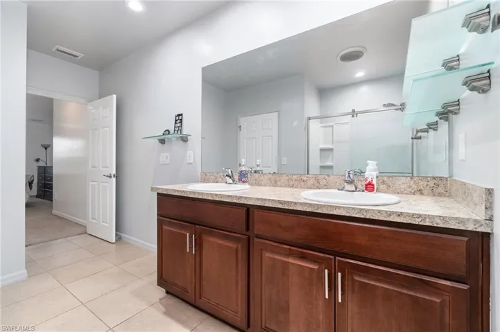 Primary bathroom with dual vanity and tile floors