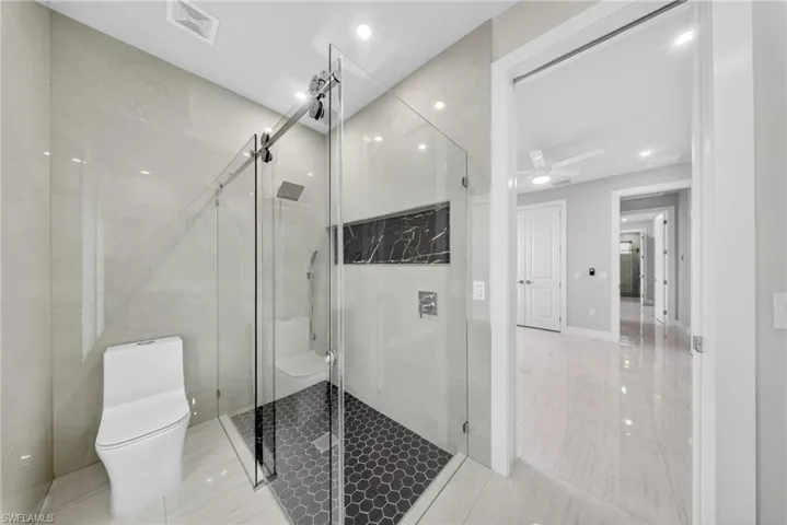 Contemporary bathroom featuring a frameless glass shower enclosure with a rain shower head