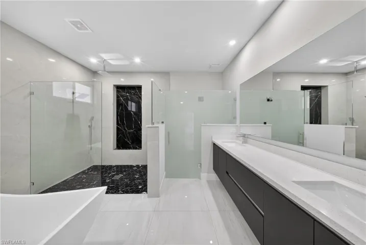 Modern bathroom featuring dual floating vanities with integrated sinks and white countertops