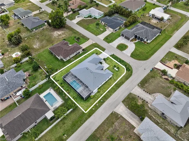 Property features a screened-in swimming pool, a gray shingle roof, and an expansive green lawn