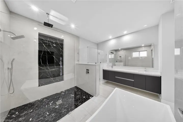 Contemporary bathroom featuring a spacious walk-in shower with dual showerheads and hexagonal tile flooring
