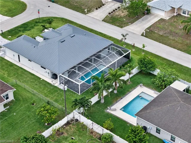 Modern residential property featuring a gray metal roof and a spacious screened-in pool enclosure