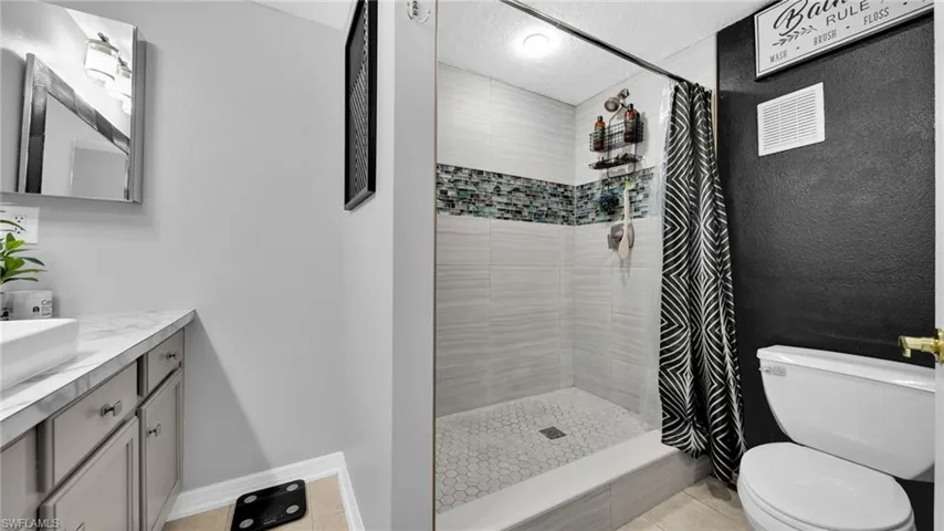 Full bathroom with vanity, a stall shower, and a textured ceiling