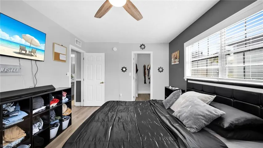 Bedroom featuring light wood-style flooring, a spacious closet, and ceiling fan