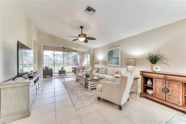 Tiled living room featuring ceiling fan and lofted ceiling