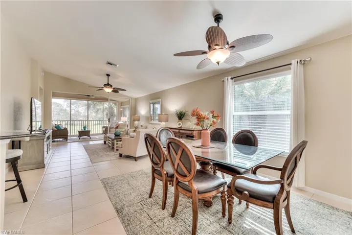 Dining room featuring light tile patterned flooring, plenty of natural light, vaulted ceiling, and ceiling fan