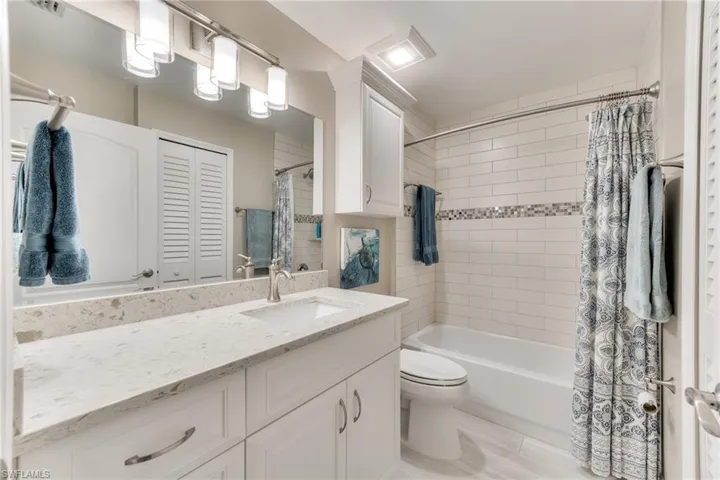 Full bathroom featuring shower / bath combo with shower curtain, toilet, and vanity